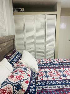a bedroom with two beds with pillows and a closet at New Kingston Paradise in Kingston