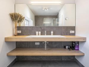 une salle de bain avec un lavabo et un miroir dans l'établissement Zentral, à Hopfgarten im Brixental 21 autres photos