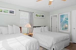 a white bedroom with two beds and a ceiling fan at The Ridgeland Trendy Tudor-15 mins to Downtown in Chattanooga