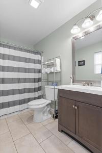 a bathroom with a toilet and a sink and a mirror at The Ridgeland Trendy Tudor-15 mins to Downtown in Chattanooga +28 photos