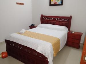 a bedroom with two beds and a wooden headboard at Hotel Dainner in Plato