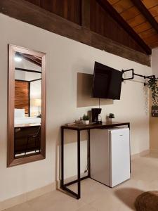 een kamer met een tafel met een televisie en een spiegel bij Casa Victoria Malecon in Puerto Vallarta