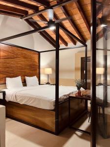 ein Schlafzimmer mit einem Himmelbett und einem Schreibtisch in der Unterkunft Casa Victoria Malecon in Puerto Vallarta