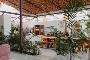 uma sala de jantar com mesa e plantas em La Tribu Boutique Hostel for women em Puerto Viejo