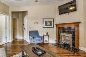 sala de estar con chimenea y silla azul en Sweet on Strong Street - Unit A, en Pensacola