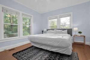 a white bedroom with a large bed with windows at Crafty in Haymount- Mins to Downtown Fayetteville! in Fayetteville