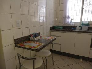 cocina con encimera con 2 taburetes y mesa en Murilo House en São José