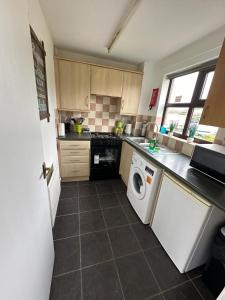 a kitchen with a washer and dryer in it at Homely Milton Keynes Stay! in Milton Keynes