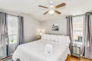 a bedroom with a white bed with a ceiling fan at North Highlands Nest- Unit D in Pensacola