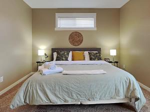 een slaapkamer met een groot bed en 2 handdoeken bij Rockaway Rookwood Retreat- Unit 1 in Indianapolis