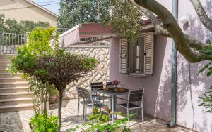 a patio with a table and chairs in front of a house at Apartments Lila in Cres