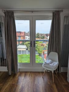 um quarto com uma janela e uma cadeira com vista em Luxury Hotel Rooms em Palmers Green