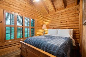 um quarto com uma cama num chalé de madeira em Oak Hill Cabin em Somerset