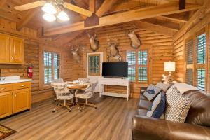a living room with a couch and a tv in a log cabin at Oak Hill Cabin in Somerset