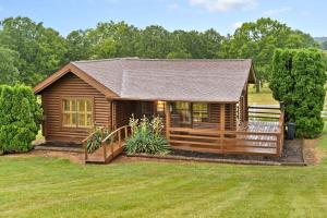 a log cabin with a deck in a yard at Oak Hill Cabin in Somerset