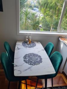 mesa de comedor con sillas verdes y ventana en Paris studio, en Auckland 20 fotos más