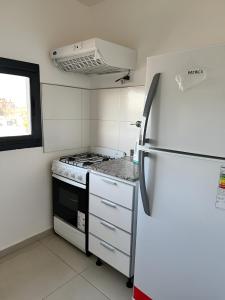 een keuken met een fornuis en een koelkast bij La Riviera / María II - CON COCHERA INCLUIDA in Villa María