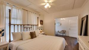 a bedroom with a large white bed and a window at Flamingle in Fushia- Unit A- Steps to the Beach! in Tybee Island