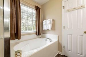 a white bath tub in a bathroom with a window at Aerie Oaks Cottage-5min to Lake, 20min to Columbia in Lexington +60 photos