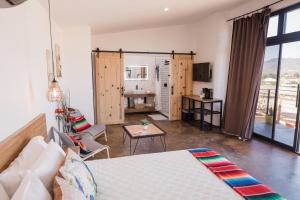 een woonkamer met een bed en een tafel bij Villa Loar, Valle de Guadalupe in El Porvenir