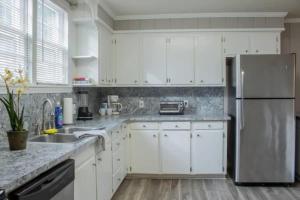 コロンバスにあるThe Graduation Getaway Near Downtown & Benningの白いキャビネットとステンレス製の冷蔵庫を備えたキッチン