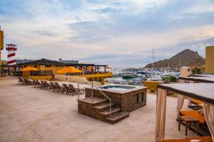 um pátio com mesas e cadeiras e uma marina com barcos em Marina Junior suite em Cabo San Lucas