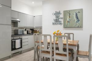 a kitchen with a table and chairs in a kitchen at Little Venice Maisonette in London