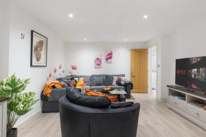 a living room with a couch and a tv at Little Venice Maisonette in London