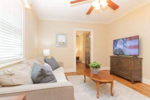 een woonkamer met een bank en een flatscreen-tv bij Near Downtown&Parks- The Cozy Guest Cottage in Columbus