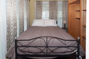 Bett in einem Schlafzimmer mit Bettrahmen in der Unterkunft The Columbus Cottage Mins to Benning Downtown in Columbus