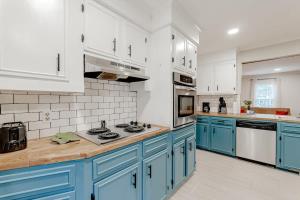 a kitchen with blue cabinets and white appliances at Settle Inn-- 10mi to Columbia, Mins to Lake Murray in Irmo