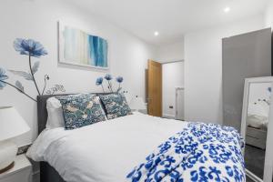 a bedroom with a bed with blue flowers on it at Little Venice Maisonette in London