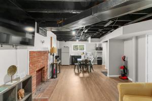 a living room with a brick fireplace and a dining room at Near Hospital & Dining- Beds on Broadmoor - Unit B in Birmingham