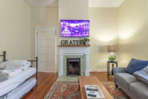 a living room with a couch and a fireplace at The Sunny Southern Manse Front Walk Downtown in Columbus