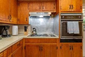 uma cozinha com armários de madeira e um forno com placa de fogão em Family-Friendly Near Benning The Crimson Ranch em Columbus