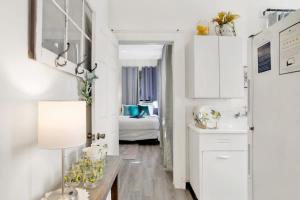 a kitchen with white cabinets and a table with a lamp at Charming Midtown Apt - Hannon Hideaway Unit A in Mobile