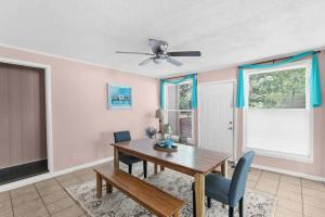 a dining room with a table and a ceiling fan at 10 Mins to Legion Field Stadium- Blushing Bungalow in Birmingham
