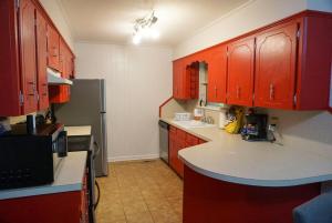 eine Küche mit roten Schränken und einer weißen Arbeitsplatte in der Unterkunft Mins to River Mountain Park Dining & Shopping in Little Rock