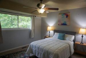 Schlafzimmer mit einem Bett, einem Deckenventilator und einem Fenster in der Unterkunft Mins to River Mountain Park Dining & Shopping in Little Rock