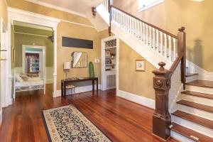 ein Wohnzimmer mit einer Treppe und einer Treppe in der Unterkunft Goldfinch Mansion Historic Luxury on the Park in Columbus