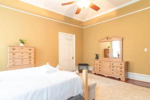 - une chambre avec un lit, une commode et un miroir dans l'établissement Bumblebee Mansion w Tiny Home Historic Modern, à Columbus