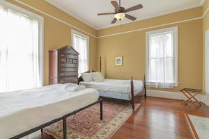 ein Schlafzimmer mit zwei Betten und einem Deckenventilator in der Unterkunft Bumblebee Mansion w Tiny Home Historic Modern in Columbus