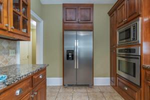 eine Küche mit Edelstahlkühlschrank und Schränken in der Unterkunft Bumblebee Mansion w Tiny Home Historic Modern in Columbus