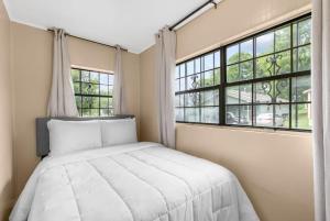 una camera da letto con un letto e due finestre di 10 Mins to Downtown Birmingham- Fresh in Fairfield a Fairfield
