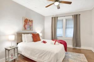 Charming Midtown Apt - Hannon Hideaway Unit C في موبايل: غرفة نوم بسرير أبيض ومروحة سقف