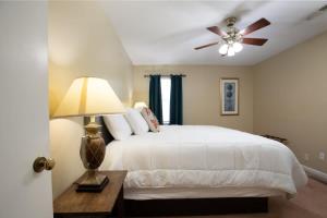 1 dormitorio con 1 cama blanca y ventilador de techo en The Monterey Maison-20min N of Downtown, 6BR en Birmingham