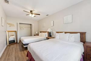 a bedroom with two beds and a ceiling fan at Wistful on Washington-Moon River District in Savannah