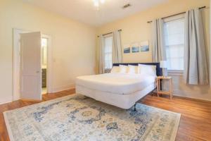a bedroom with a large white bed and a rug at Near Downtown Parks & Museum - Midtown Two-Units in Columbus