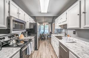 a kitchen with white cabinets and white counter tops at Fenced Yard - Comfy & Convenient in Cordova in Memphis