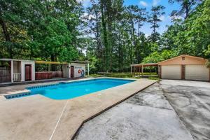 a swimming pool in a yard with a house at Fenced Yard - Sassy in the Sun in Savannah
